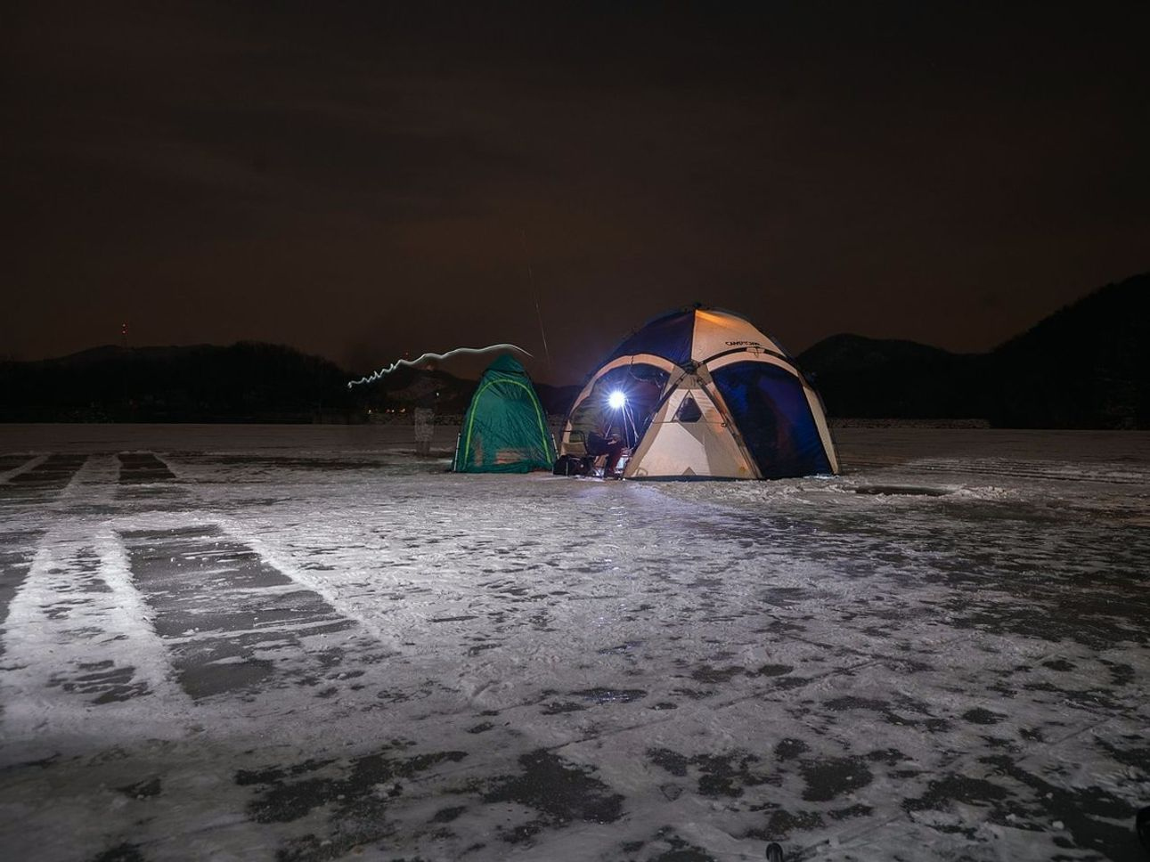 Vista del lago de montaña cubierto de hielo al amanecer