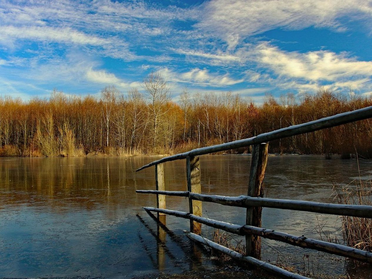 Agua tranquila del lago bajo el hielo con colinas bajas